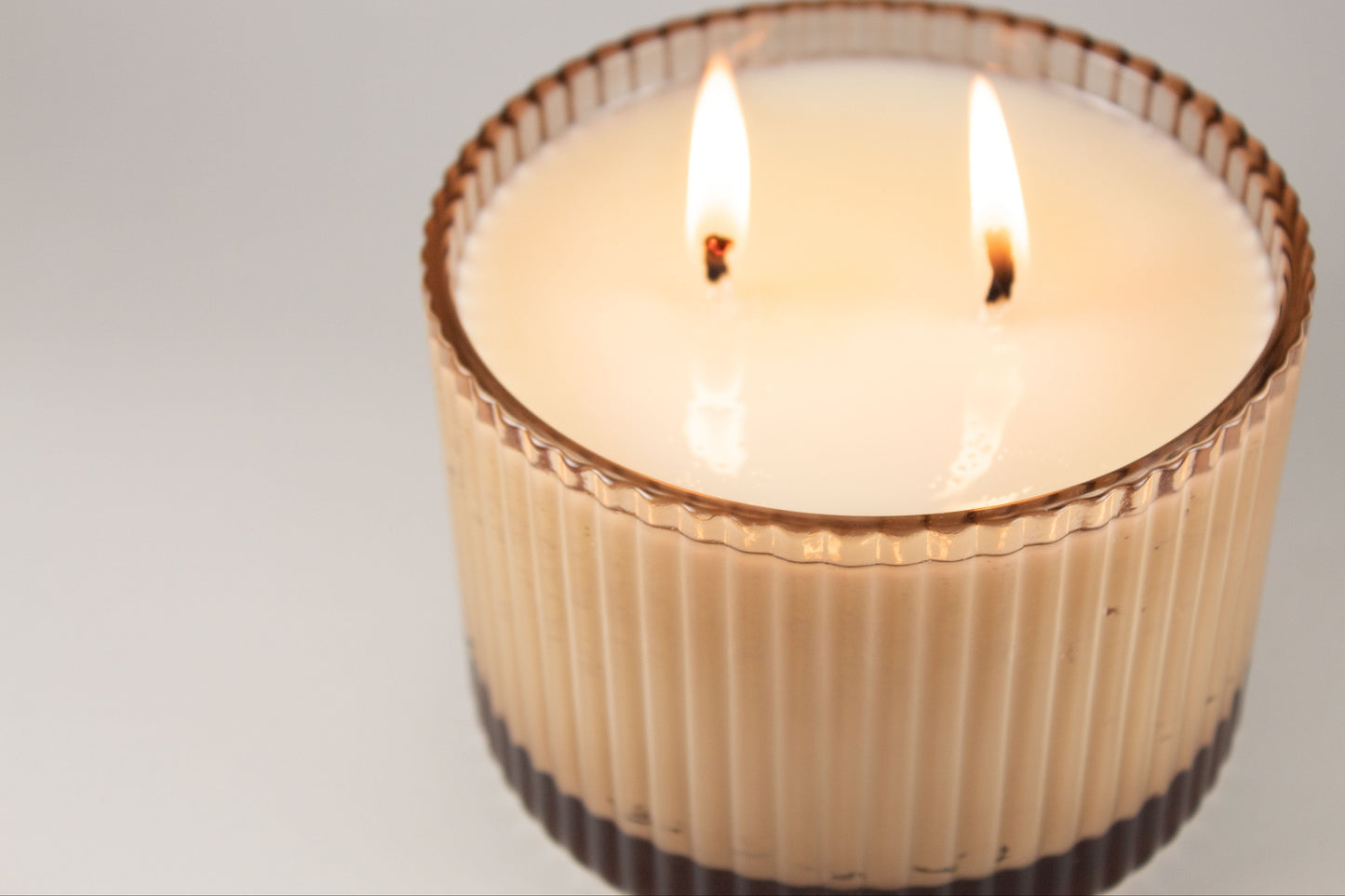Close-up of fluted glass candle jar by Unplug Soy Candles